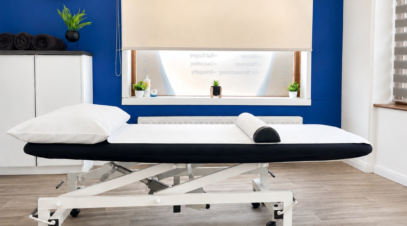 Zoe’s treatment room - clean massage couch set against a calm blue accent wall